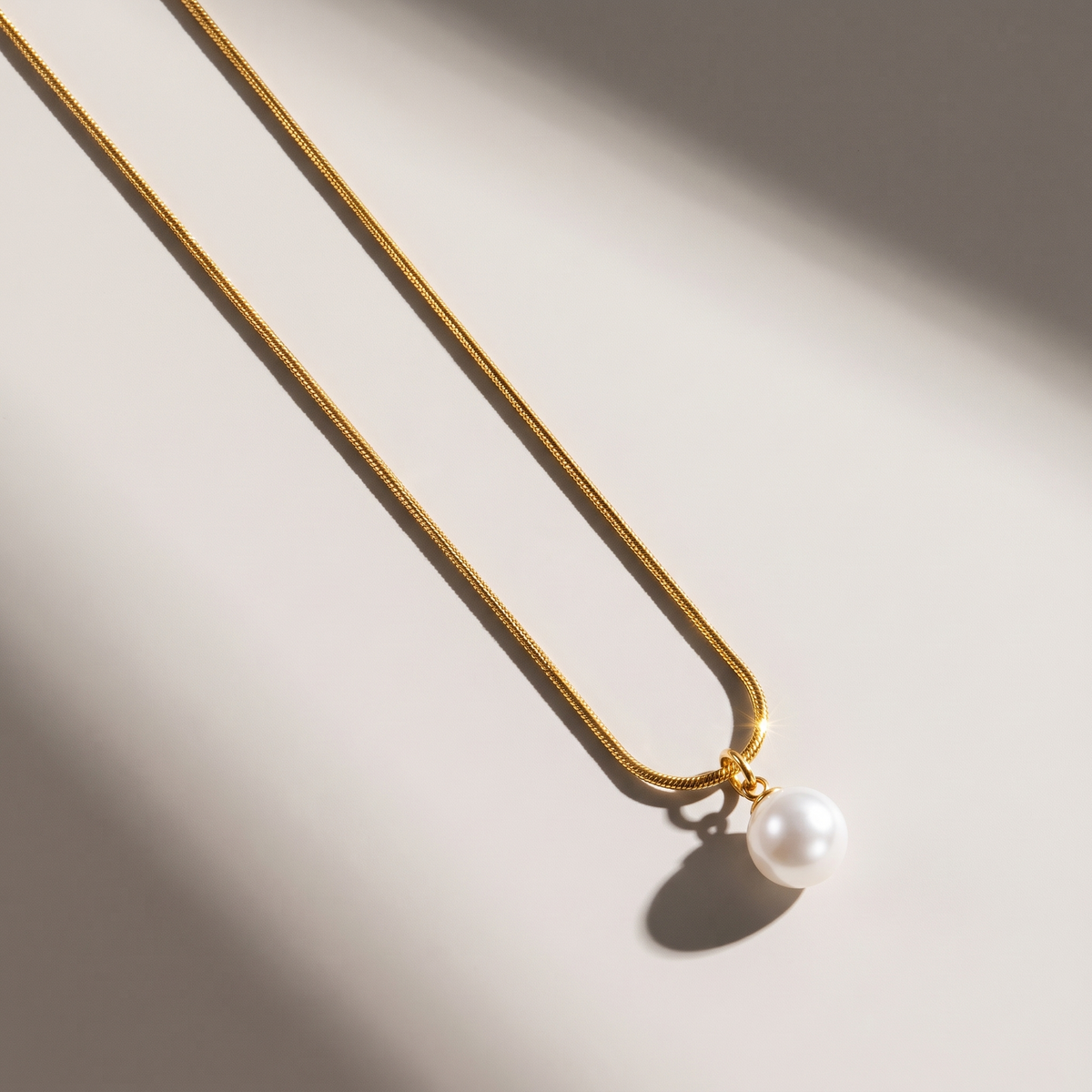Luna Pearl Necklace in gold finish - ARWELY editorial still life with a hard shadow