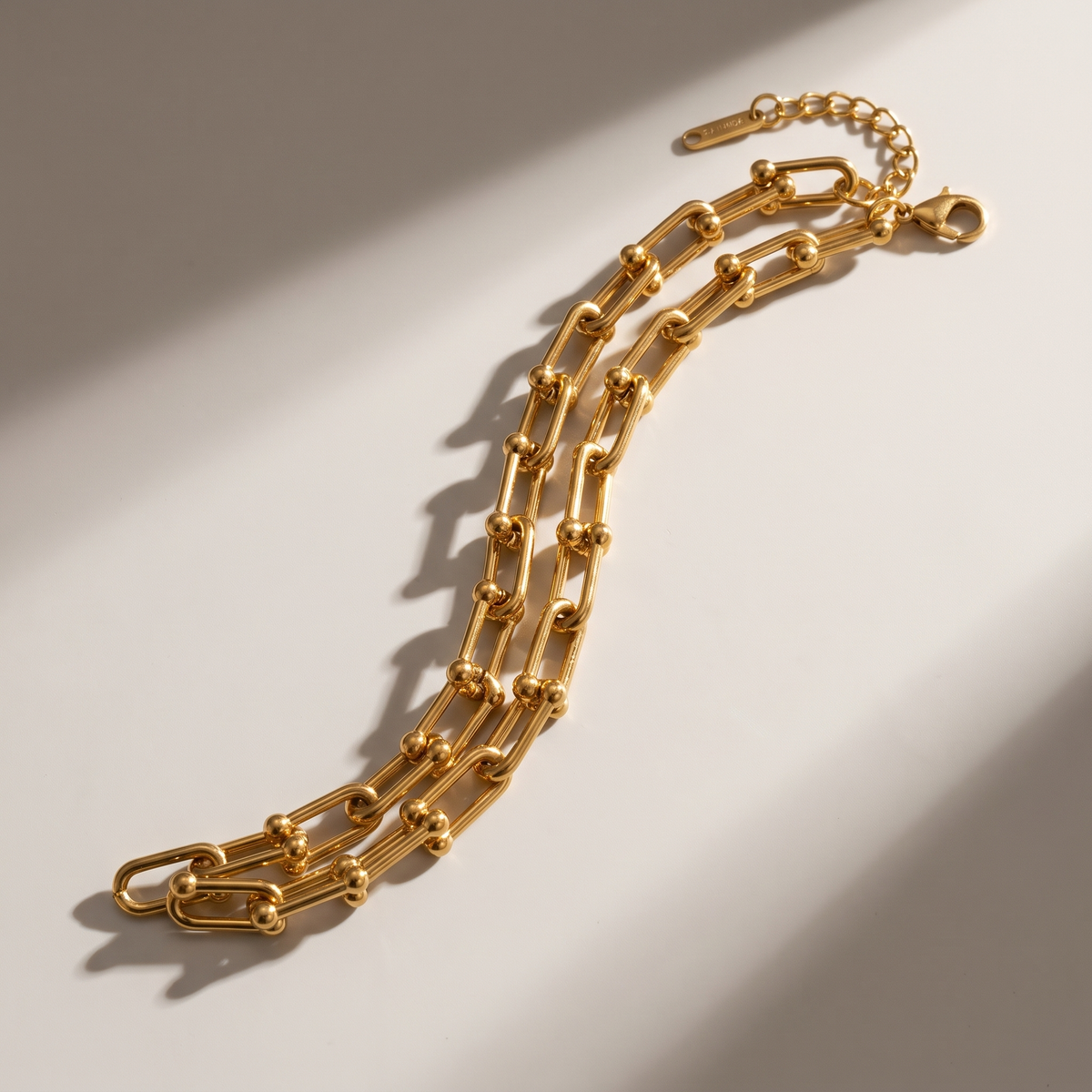 Vera Paperclip Bracelet in gold finish - ARWELY editorial still life with a hard shadow