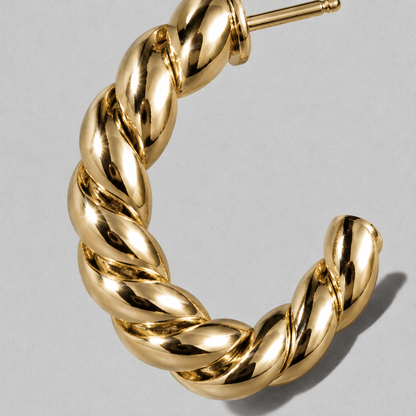 Arc Hoop Earring close up on a diagonal, hard light across the twist
