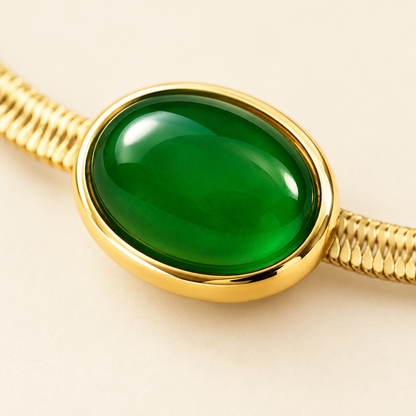 Macro detail of one green cabochon in its polished gold bezel on the Cléo Necklace