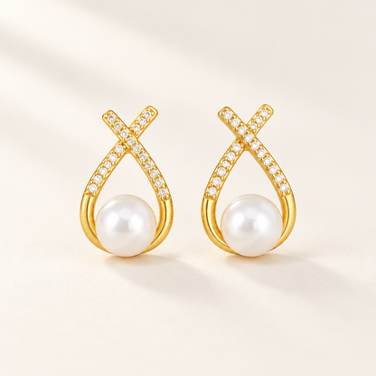 Ruban Pearl Earrings — a pair of gold ribbon studs cradling a pearl