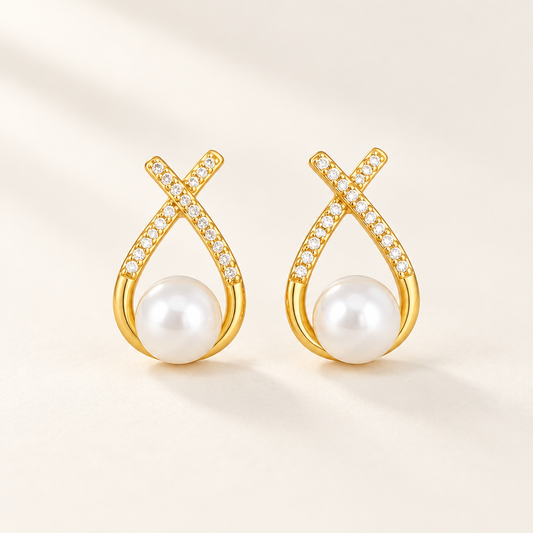 Ruban Pearl Earrings — a pair of gold ribbon studs cradling a pearl