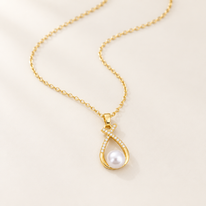 Ruban Pearl Necklace — a gold ribbon curling around a single pearl